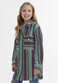 Värikäs kuviollinen puserotakki, jossa on vihreitä, vaaleanpunaisia ja sinisiä raitoja. Kaksi rintataskua ja kultaiset napit. Kangas näyttää olevan teksturoitu.