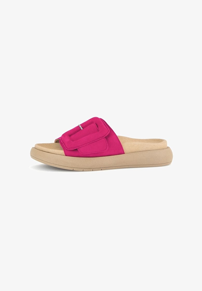 Sandale mule à semelle beige avec semelle intérieure rembourrée et large bride rose vif ornée d'une grande boucle carrée.