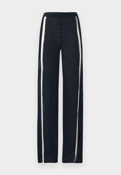 Παντελόνια φαρδιά από υφή ύφασμα σε σκούρο ναυτικό μπλε, με κάθετες λευκές ρίγες στα πλευρά και ριμπ ζωνάρι στη μέση.