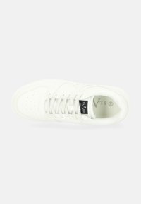White sneaker with a smooth leather upper, perforated toe box, and flat laces. Features a black label inside with the brand name.