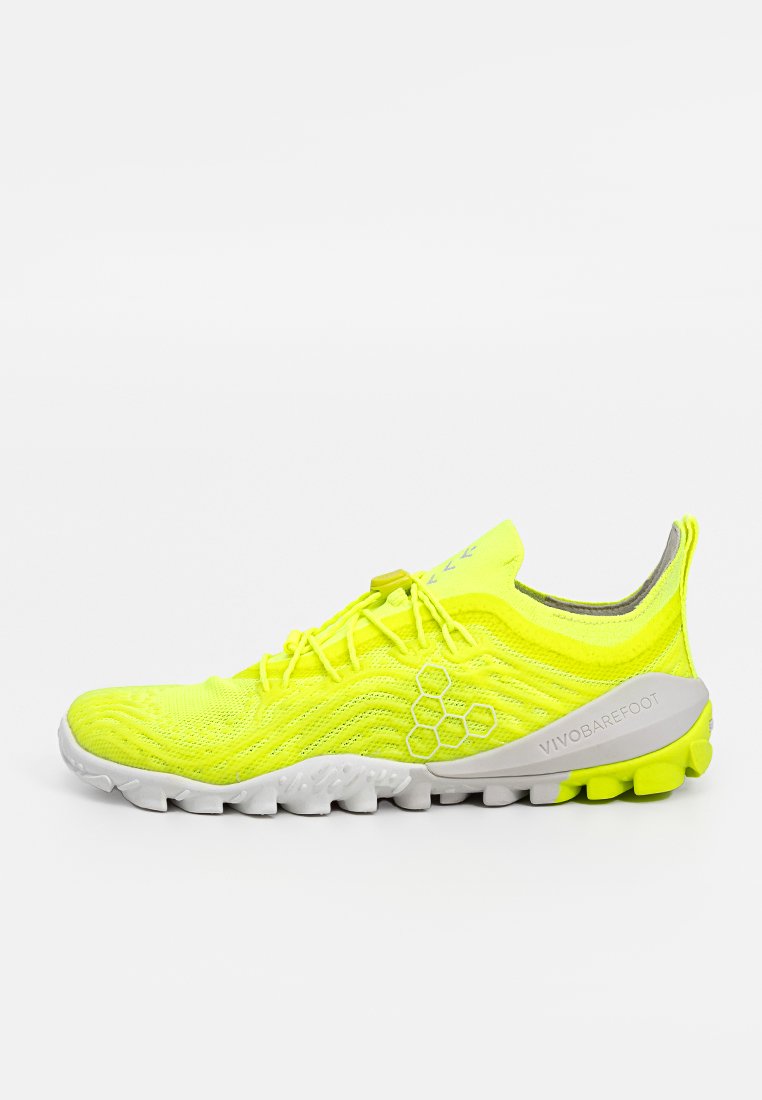Zapatillas deportivas amarillas con parte superior de malla texturizada, con una suela gris y distintivos acentos amarillos. Diseño ligero y flexible.
