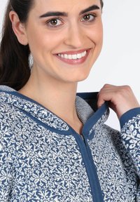 Blau-weißer Hoodie mit Muster, einem Kordelzug an der Kapuze, einem Frontreißverschluss und weichem Material, ausgestattet mit einem floralen Design und kontrastierendem Besatz.