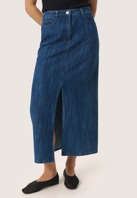 Temno moderna denim maksi krila z razporkom spredaj, visokim pasom in klasičnim petkotnim dizajnom. Nosite z črnimi ravnimi čevlji.