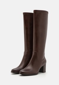 Bocanci din piele maro, până la genunchi, cu vârf rotund, toc pătrat și panouri laterale. Textură netedă, cusături minime, design elegant.