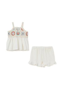 Completo a due pezzi composto da un top senza maniche con ricami floreali in rosa e blu, e pantaloni corti bianchi coordinati con orlo arricciato. Realizzato in cotone.