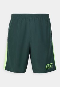 Shorts de Nike en verde oscuro con paneles laterales en verde neón. Fabricados con material ligero, cuentan con una cinturilla elástica y un logo bordado.