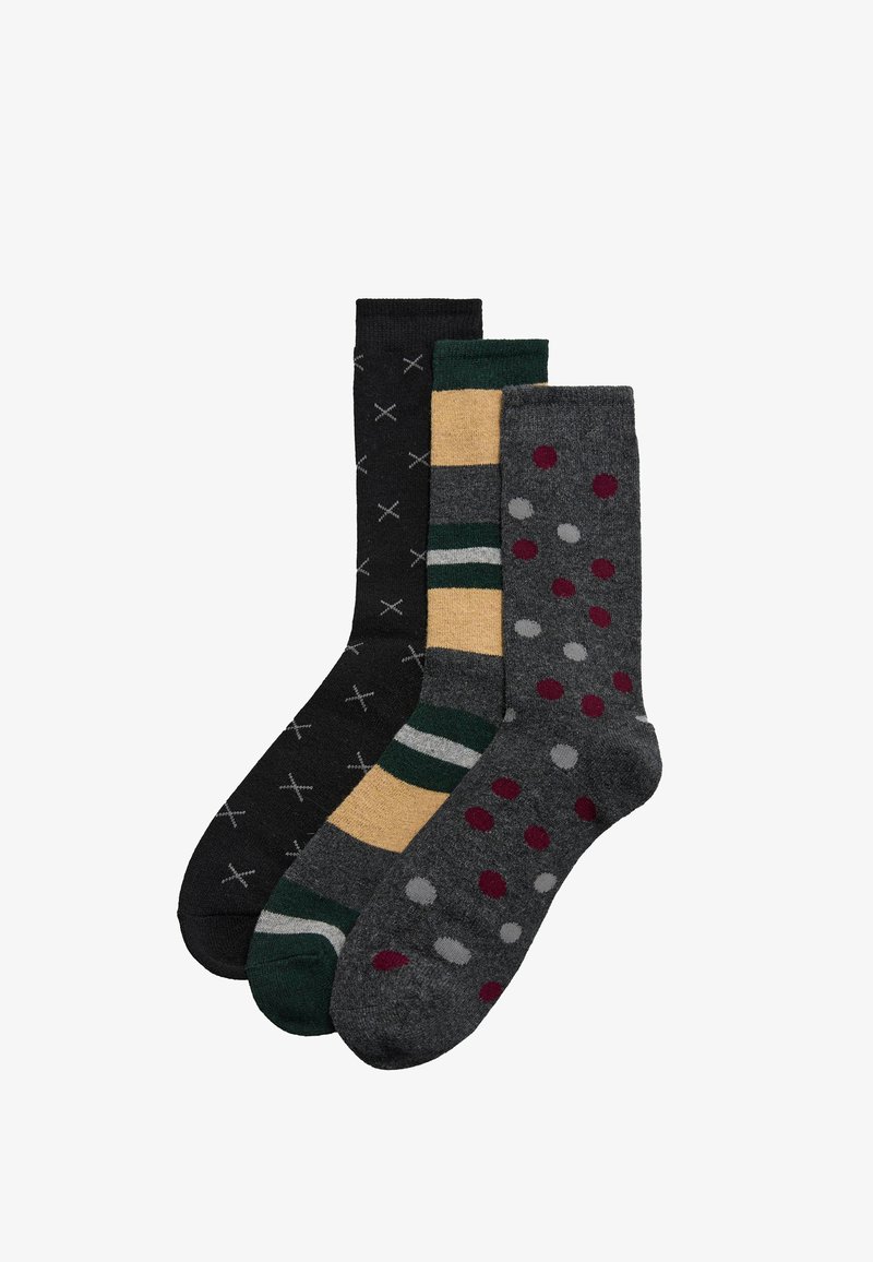 Tres pares de calcetines: negros con patrón de cruces blancas, amarillos con rayas verdes y grises con puntos rojos y grises, todos de longitud media hasta la pantorrilla.