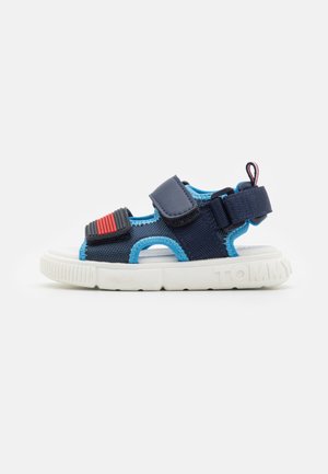 Sandalo da bambino con punta aperta in blu navy e azzurrino, suola bianca, cinturini regolabili e dettaglio rosso sulla cinghia frontale.