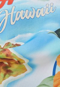 Cotton fabric with a light blue background featuring a colorful floral and mountain print, along with the word "Hawaii" in white cursive.