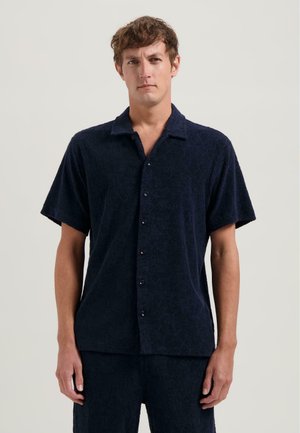Navy short-sleeve shirt made of textured fabric with geometric patterns, featuring a button-down front and a relaxed collar design.