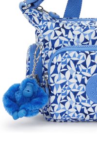 Borsa blu a fantasia con forme geometriche. Include un portachiavi a forma di scimmia in peluche blu e un tessuto testurizzato. Diverse tasche con zip.