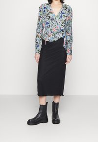 Floral wrap blouse in light blue, black pencil skirt, and black ankle boots. Blouse features long sleeves and gathered side detail.