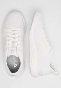 Witte sport schoenen met een bovenwerk van mesh voor ademend vermogen, platte veters, gevoerd kraag en gestructureerde zijpanelen met een rubberen zool.