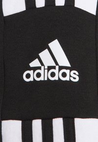 Calza sportiva nera con design a tre strisce bianche e logo adidas ricamato in bianco su tessuto nero. Materiale morbido e testurizzato.