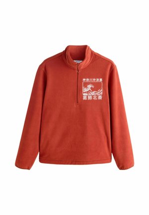 Fleecepullover i klar orange färg, med hög krage och halv dragkedja framtill. Har ett vitt grafiskt mönster på bröstet. Mjuk textur.