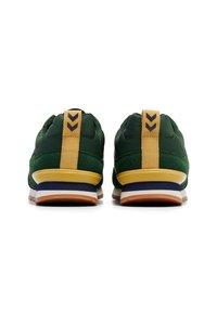 Green athletic shoes with a textured upper, yellow heel tab, and multi-layered sole with orange, blue, and white accents.