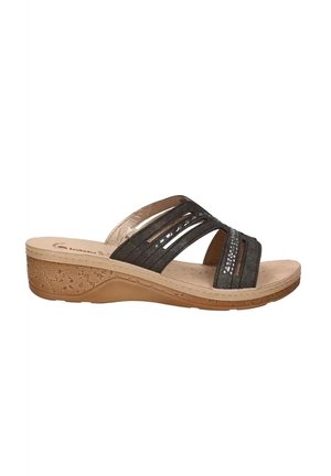 Sandalo marrone con zeppa, cinturini incrociati, piccoli dettagli con borchie, punta aperta e suola strutturata color beige chiaro, visto di lato.