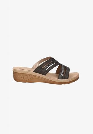 Sandalo marrone con zeppa, cinturini incrociati, piccoli dettagli con borchie, punta aperta e suola strutturata color beige chiaro, visto di lato.