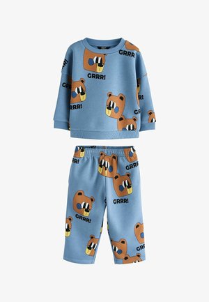 Blaues zweiteiliges Kinderoutfit mit langärmligem Oberteil und Hose, mit Cartoon-Bärengesichtern und "GRRR!" Textmuster überall.