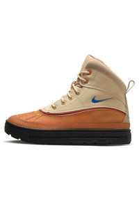High-top sneaker with beige, orange, and black leather material. Features a blue logo, textured panels, and a rubber sole for traction.