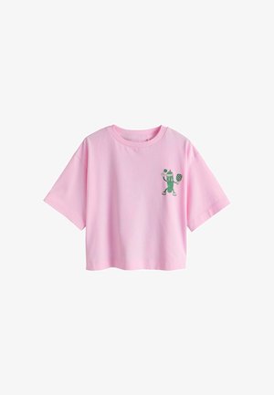 T-shirt rosa corta a maniche corte con un piccolo personaggio di cetriolo verde che gioca a pickleball stampato sul petto a sinistra.