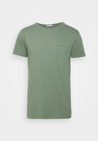 Olivově zelené bavlněné tričko s krátkými rukávy, kulatým výstřihem a malým potiskem textu "YOUNG POETS SOCIETY" na levé hrudi.