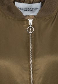 Olive green bomber jacket with a silver zipper, ribbed collar and cuffs, smooth texture, and a quilted lining inside.