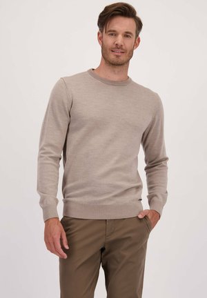 Lichtbeige trui van een zachte stof, met een ronde hals en ribgebreide manchetten en onderrand. Gecombineerd met olijfgroene broek.