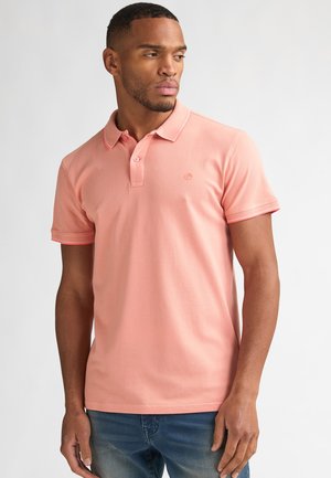 Polo rose en coton, doté d'un col classique, d'une patte de boutonnage à deux boutons et d'un liseré contrastant sur les manches. Logo simple sur la poitrine.