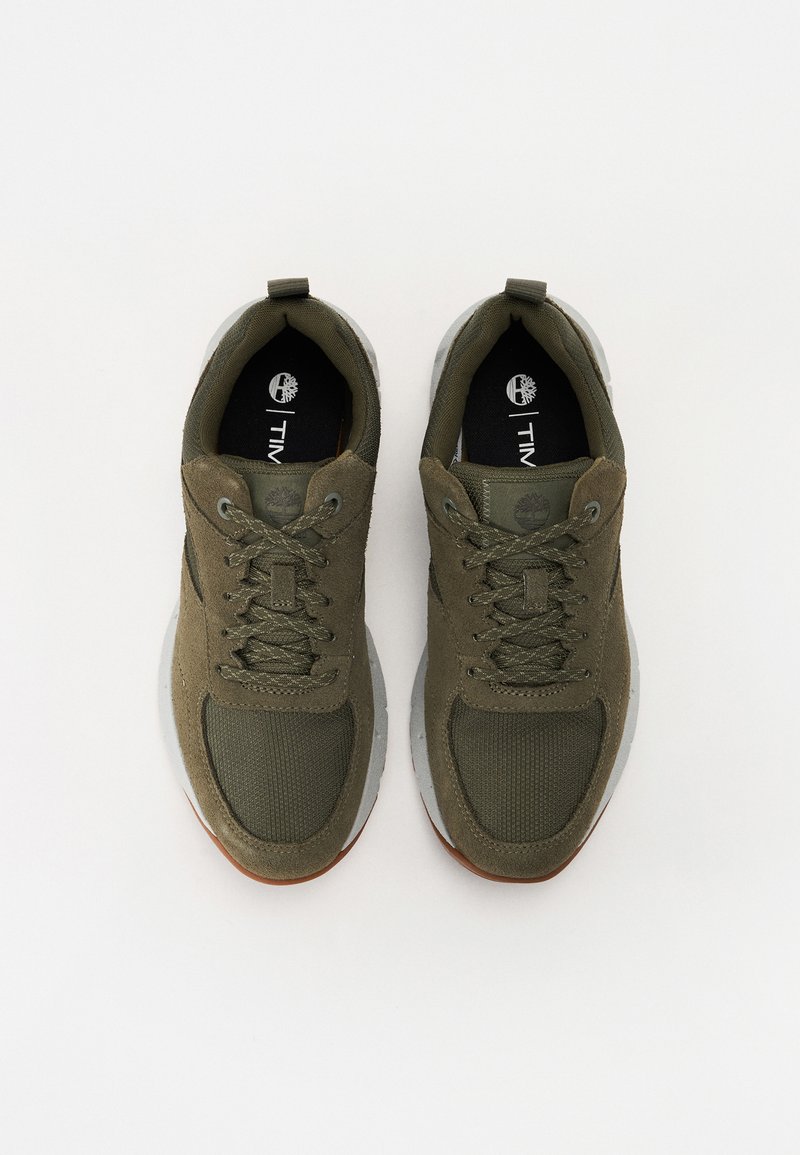 Zapatillas verde oliva fabricadas con malla transpirable y materiales sintéticos, con una superficie texturizada, punta redonda y suela de goma.