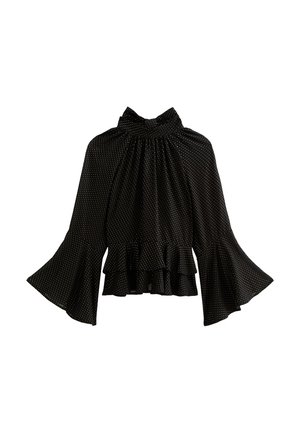 Blusa nera a maniche lunghe con piccoli pois bianchi, colletto alto arricciato, maniche a campana e dettaglio in pizzo sul fondo.
