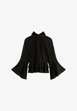 Blouse noire à manches longues avec petits pois blancs, encolure haute froncée, manches évasées et détail de bordure à volants.