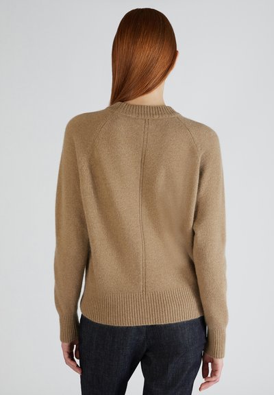 Maglione lavorato a maglia beige con collo alto a coste, maniche lunghe e orlo a coste. Tessuto morbido e design semplice, adatto per essere indossato a strati.