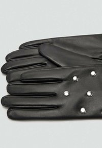 Guantes de cuero negro con una textura lisa, que presentan cinco dedos y remaches plateados como acentos decorativos en la zona de la muñeca.