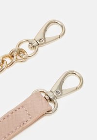 Two silver metal lobster clasps attached to a gold chain and a textured pink strap on a white background.