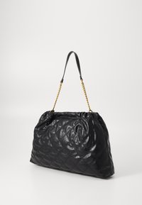 Bolsa de mão em couro preto acolchoado com o topo franzido, apresentando uma alça curta em couro e um detalhe em corrente dourada. Textura suave, tamanho médio.