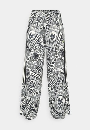 Pantalons larges en noir et blanc avec un imprimé tropical géométrique, présentant divers motifs et textures. Taille élastique pour le confort.