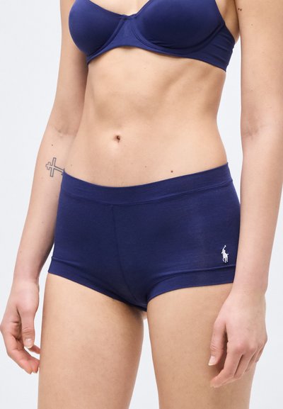Γυναικείο σώμα με μπλε-σκούρο σουτιέν και αντίστοιχο μποξεράκι, με μικρό λογότυπο Polo Ralph Lauren στο αριστερό ισχίο.