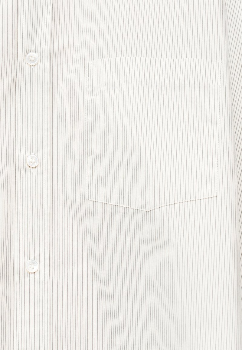 Witte blouse met dunne verticale zwarte strepen en een borstzak aan de linkerkant.