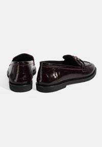 Bordeaux gepatenteerde leren loafers met een textuur van krokodillenpatroon, voorzien van een decoratieve gesp en zwarte rubberen zolen. Laag uitgesneden ontwerp.