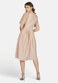 Spitzenkleid in sanftem Pink, mit kurzen Ärmeln, einem taillierten Oberteil und einem schwingenden Rock. Verfügt über aufwendige Muster und subtile Strukturdetails.