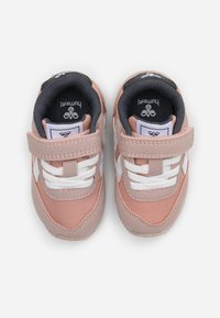 Helle pinke Kindersneaker mit weißen Akzenten, Klettverschluss und strukturierten Gummisohlen. Gepolstertes graues Innenfutter für Komfort.