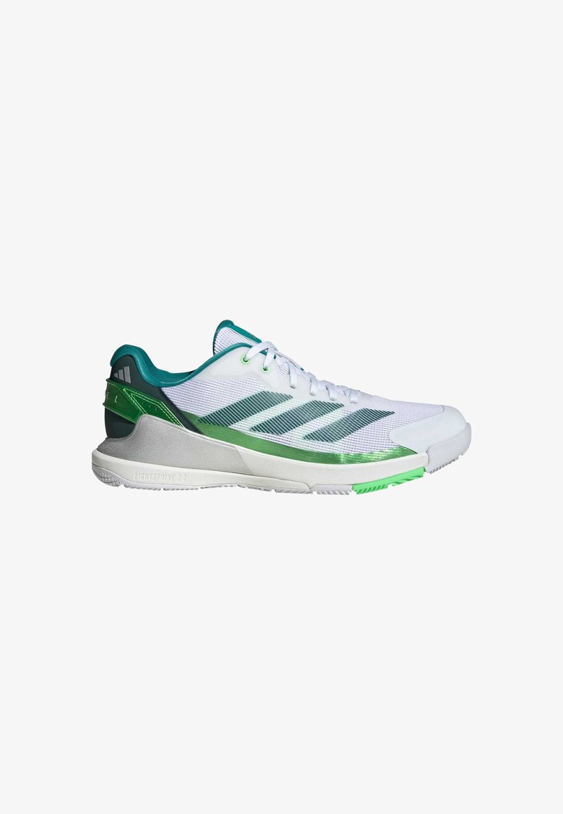 White athletic shoes with green accents, mesh upper, textured sides, three stripes logo, and rubber sole featuring a green outsole detail.