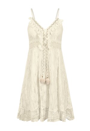 Robe blanche en dentelle avec des fines bretelles, motifs floraux, un lien tressé à l'avant avec des pompons et une finition évasée.