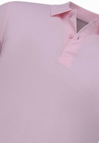 Roze polo shirt met een kraag, twee knopen en een gladde textuur. Heeft een klassiek ontwerp zonder extra patronen of accenten.