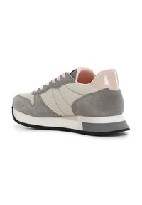 Graue und beige Sneaker aus Wildleder, mit matter Oberfläche, rosa Schnürsenkeln und einem glänzenden rosa Akzent an der Ferse. Geformt im Retro-Design.