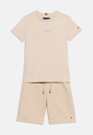 Beige Tommy Hilfiger Baumwoll-T-Shirt mit kurzen Ärmeln, Logoaufdruck und passenden Shorts mit Kordelzug und kleinen Logopatches.