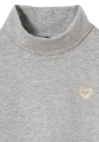 Hellgrauer Rollkragenpullover mit einem kleinen goldenen Glitz HERZ-Symbol auf der linken Brustseite.