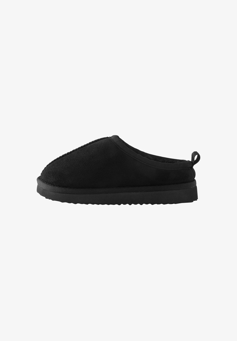 Chausson noir sans lacets avec dessus en peluche, semelle épaisse et rembourrée, et languette en boucle au talon pour un enfilage facile.