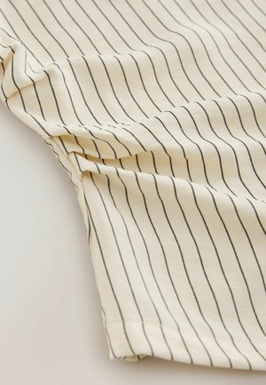 Hellbeiger Stoff mit senkrechten schwarzen Nadelstreifen, der eine weiche Textur und ein leicht drapiertes Design mit einem genähten Saum aufweist.